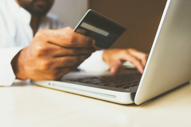 Paying a bill online with a card at a laptop